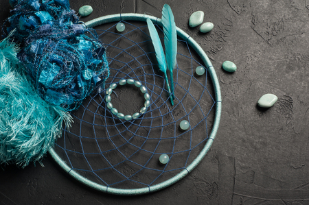 Blue dream catcher flat lay on black concrete background with gemstone beadsの写真素材