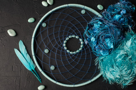 Blue dream catcher flat lay on black concrete background with gemstone beadsの写真素材