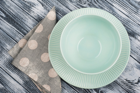 Empty blue plates and napkin over wooden table background. View from above with copy spaceの写真素材