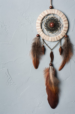 Beige brown dream catcher with feathers on concrete wall. Copyspace for textの写真素材