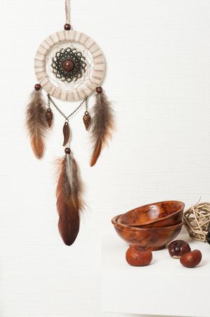 Beige brown dream catcher with feathers on white wall. Copyspace for textの写真素材