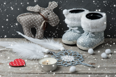 Silver Christmas decorations, dream catcher and lit candle on wooden background with snow.の写真素材