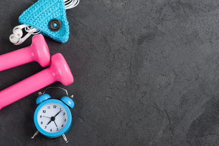 Good morning flat lay with blue alam clock, pink dumbbells and cord holder for earphones. Top viewの写真素材