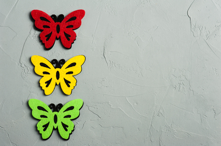 Red yellow green color textile butterflies as traffic light on concrete grey background. Flat lay, view from above, copyspace for textの写真素材