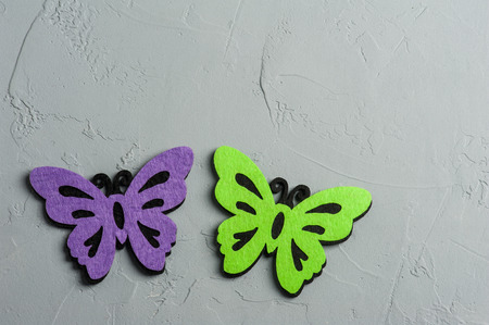 Purple and green textile butterflies on concrete grey background. Flat lay, view from above, copyspace for textの写真素材