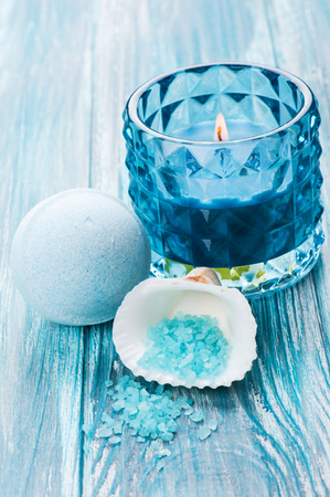 SPA still life, closeup of blue lit candle, salt and bath bomb on wooden background. Space for textの写真素材