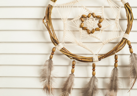 Dream catcher with brown feathers in the interiorの写真素材