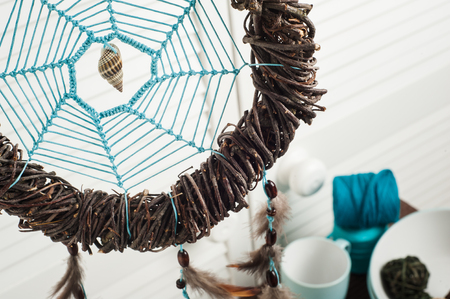 Dream catcher with brown feathers in the interior with nautical decorの写真素材