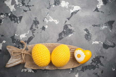 Yellow crocheted easter eggs and heart on a concrete background. Scandinavian decor, Easter or Valentines Day compisition. Copyspace for textの写真素材