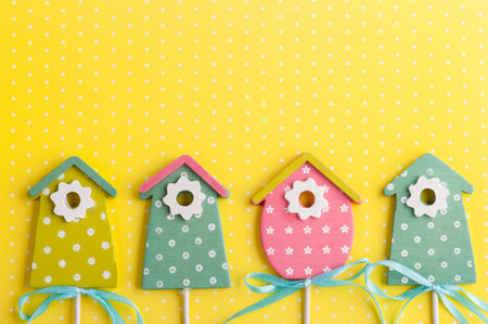 Colorful birdhouses on yellow polka dot background. Easter concept.の写真素材