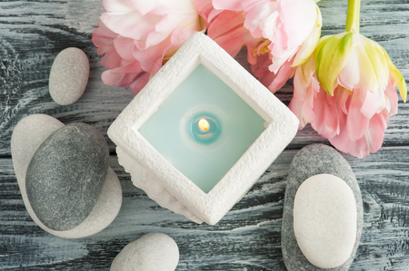 Candle and pebbles over shabby wooden background, top viewの写真素材