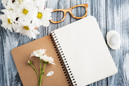 Top view of open blank notebook, pebbles, flowers. Journal or diary conceptの写真素材