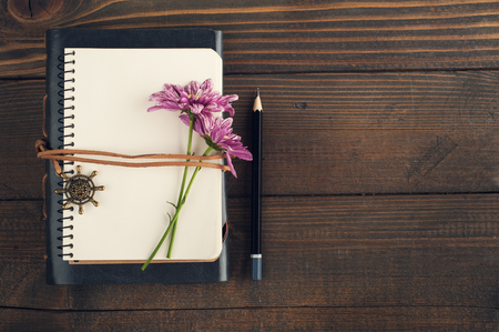 Top view of open blank notebook, flower. Travel and adventure concept, journey diaryの写真素材
