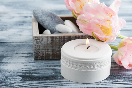 Candle and pebbles over shabby wooden background, top viewの写真素材