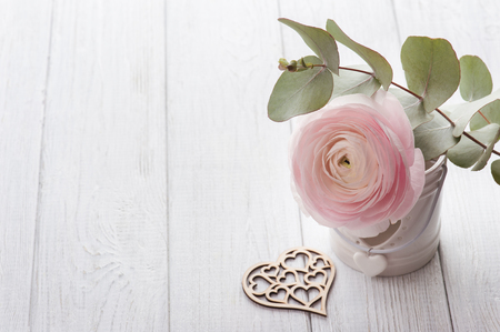 Pink ranunculus and heart on a white wooden background. Pastel colors, greeting cardの写真素材