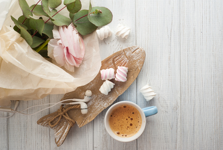 Top view of bouquet, flower, cup of coffee, earphones on white wooden background. Copy space for textの写真素材