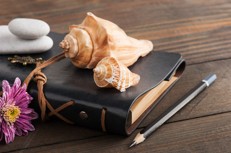 Notebook, pebbles, flower, shells. Travel and adventure concept, journey diaryの写真素材