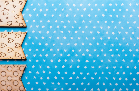 Wooden flags with stars, hearts, ronds on blue background. Greeting card conceptの写真素材