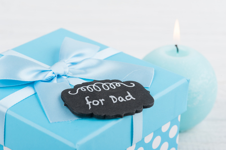 Blue gift box with ribbon on white wooden background. Father's day concept with copy spaceの写真素材