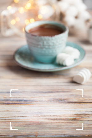 Wooden table and hot cocoa mug blurred on background. Frame for your textの写真素材