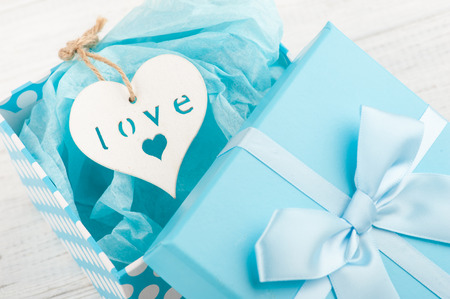 Blue gift box with heart on white wooden background. Father's day concept with copy spaceの写真素材