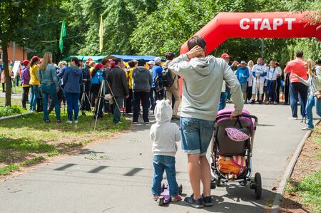 Kyiv, Ukraine - June 24, 2018: nordic walkers in park participating in Marathon. Father and kids waiting for motherのeditorial素材
