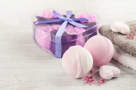SPA composition with pink bath bombs, soap roses, heart on white wooden backgroundの写真素材