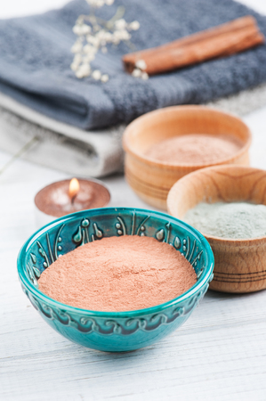 Red and blue cosmetic moroccan clay powder, spa composition with notebook on white backgroundの写真素材