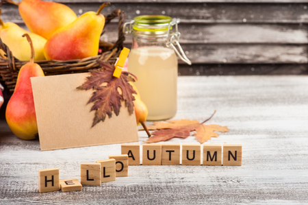 Homemade pear cider and fresh fruits on wooden table. Words Hello Autumn on foregroundの写真素材