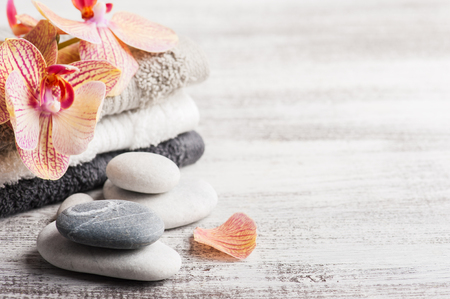 Spa still life with pebbles and red orange orchid on wooden backgroundの写真素材