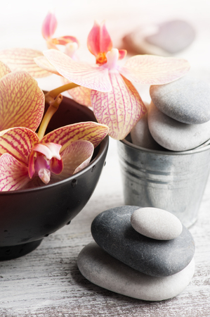Spa still life with pebbles and red orange orchid on wooden backgroundの写真素材