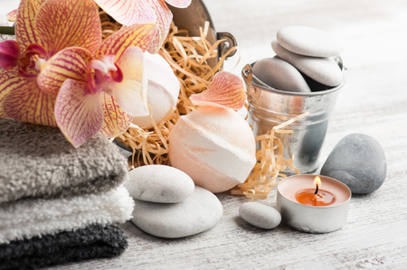 Spa still life with bath bombs, pebbles and red orange orchid on wooden backgroundの写真素材
