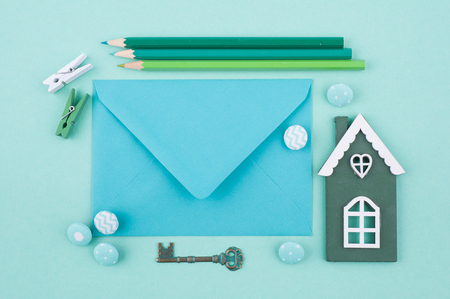 Mint green color working desk with envelope, toy house and key. Top vewの写真素材