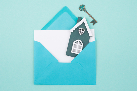 Mint green color working desk with envelope, toy house and key and empty card. Top vewの写真素材
