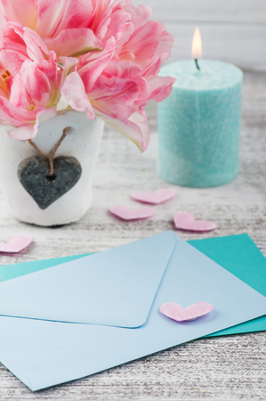 Fresh pink tulip flowers, empty envelopes on rustik wooden backgroundの写真素材