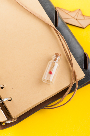 Bright summer holiday background with blank open note book, travel and nautical decor on yellow desk, top viewの写真素材