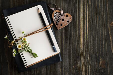 Open empty notebook with wild flowers, heart and copy spaceの写真素材
