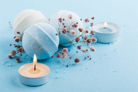 Spa set of blue bath bombs and lit candlesの写真素材
