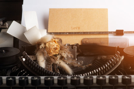 Typewriter close up and dry flowers with envelope. Valentines concept, vintage toned and kraft paper