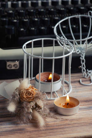Russian Typewriter close up and dry flowers with lit aroma candle. Valentines concept, vintage toned and kraft paperの写真素材