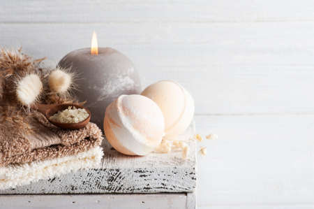 Grey lit aroma candle with bath bombs and dry flowers on rustic background. Spa arrangement with salt in monochrome styleの写真素材