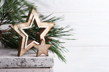Christmas decoration with wooden stars and pine tree on white rustic background. Copy space for...