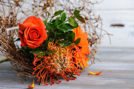 Autumnal orange red bouquet with rosa and gerbera flowers on white rustic background. For greeting cards and designの写真素材