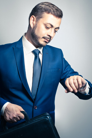 Handsome corporate businessman checking the time on his watchの写真素材