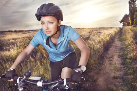 Female rider cycling on a rural road  の写真素材