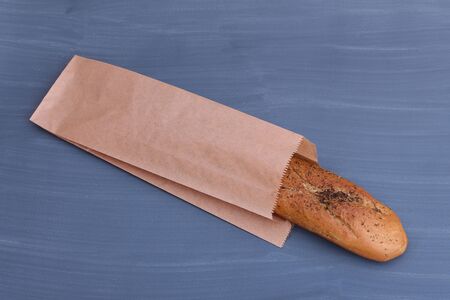 Paper bag with baguette on a gray background, top view. Space for design.の写真素材