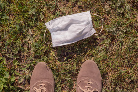 medical mask and shoes on the grass. Concept end quarantine and self-isolation