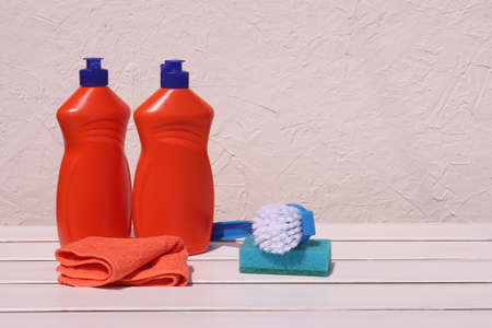 Detergents for home on the table: microfiber, brush, sponge and detergent on a white wooden background. House cleaningの写真素材