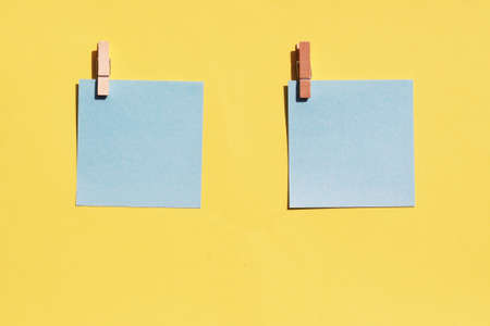 two blue sheets for writing on a yellow background. Top view, copy space.の写真素材