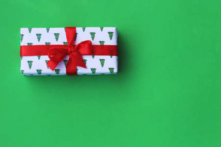 christmas gift box on a green background. Flat lay. Copy space. Postcard, layoutの写真素材